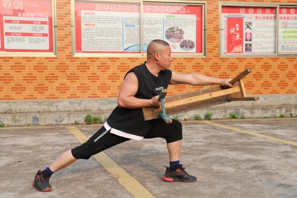 拍摄时间：2021.03.18 拍摄地点：嘉禾县文武培训学校 拍 摄 者：唐俊华 相关人员：禾仓拳传承人刘焕红 画面内容：禾仓拳《板凳术》中的“犀牛灌顶”.JPG